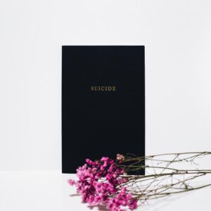 Elegant black condolence card with pink flowers on white background.